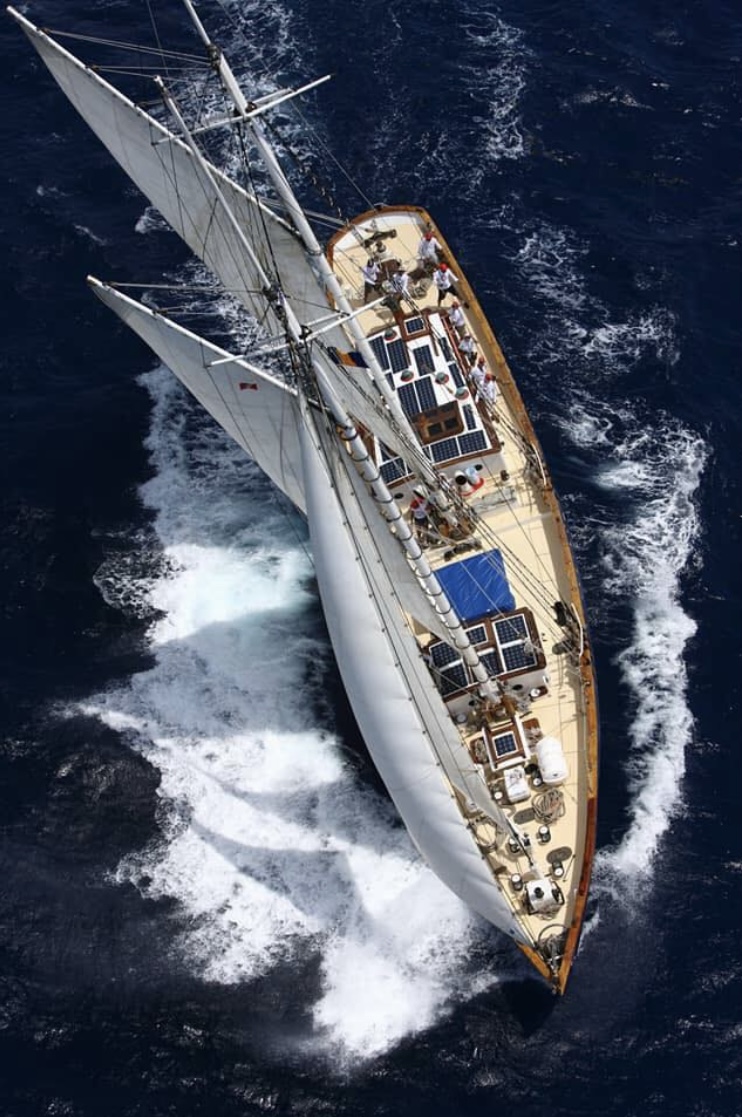 Aerial view of the schooner Ruth under sail — steel deck, full canvas and foaming wake